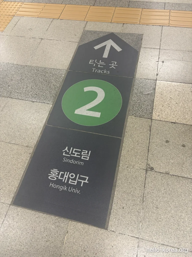 Green Line 2 floor arrow at Sadang Station marked Tracks, Sindorim and Hongik Univ.
